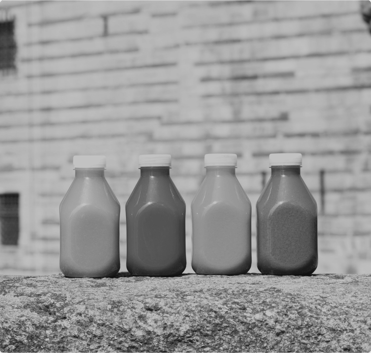 Quatre bouteilles de jus posé sur un banc