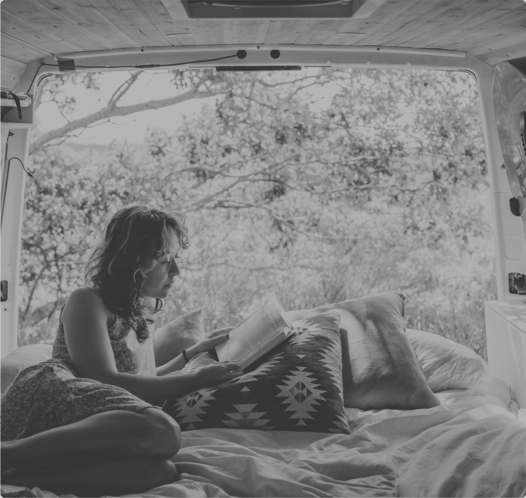 une personne lit un livre dans un van porte ouverte